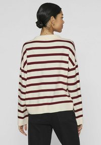Gestreifter Pullover in Creme und Bordeauxrot mit einer lässigen Passform, langen Ärmeln und einem klassischen Kragen-Design. Weicher Strickstoff.