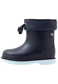 Botte en caoutchouc bleu marine avec un revers, semelle blanche, accent de cordon et logo "igor" sur le côté. Texture lisse avec bout arrondi.