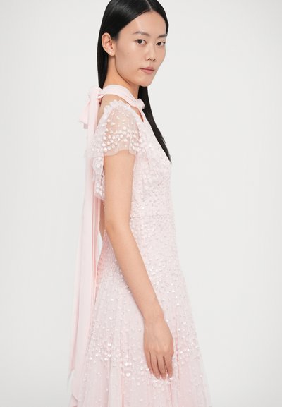 Rózsaszín ruha texturált anyagból, díszített rövid ujjakkal, bővülő szabással és hátul megkötős kialakítással.