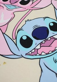 Des personnages de dessin animé avec de grands yeux noirs. Un personnage est bleu avec une large bouche montrant ses dents, tandis qu'un autre est rose et souriant. L'arrière-plan est clair.