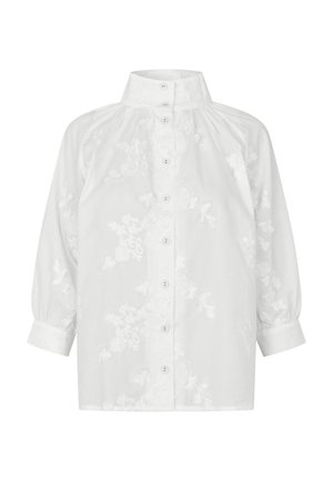 Hvid bluse med lange ærmer, høj krave, knaplukning foran, rynkede skuldre og diskret blomsterbroderi på stoffet.
