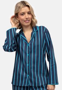 Marineblauwe pyjama set met verticale strepen in turquoise. Bevat een geknoopte top met kraag en lange mouwen, en bijpassende broek met hetzelfde patroon.