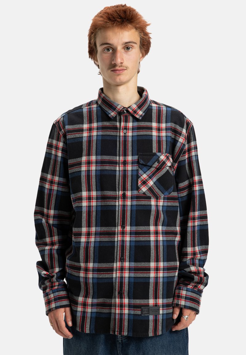 Czarna, czerwona i niebieska koszula flanelowa w kratę z kołnierzykiem zapinanym na guziki, kieszonką na piersi i długimi rękawami. Miękka struktura, klasyczny krój.