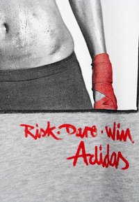 Camiseta de algodón gris con un gráfico en blanco y negro de un torso y texto en rojo que dice "Riesgo: Atrévete: Gana" y "Adidas" en la parte inferior.