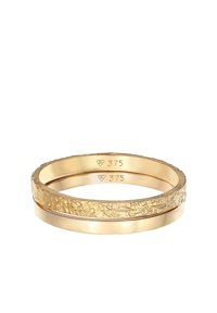 Goldring-Set mit zwei Bändern; eines hat eine strukturierte, gemusterte Oberfläche, während das andere glatt und poliert ist. Beide sind mit "375" gestempelt.