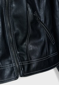 Black leather jacket with prominent stitching, zippered pocket, and smooth texture. Features a tailored fit and sleek design details.