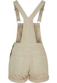 Beige overallshorts med justerbare stropper, baklommer og oppbrettede ermer, laget av et teksturert stoff med synlige sømdetaljer.