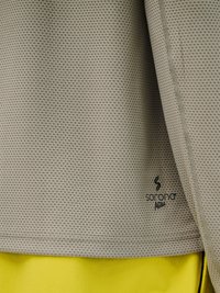 Beżowa teksturowana koszulka sportowa z logo „sorona AGILE” nad jaskrawożółtymi szortami.