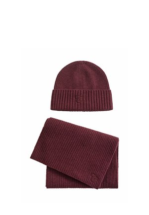 Bordeauxrote gerippte gestrickte Mütze und passender Schal, beide mit einem kleinen gestickten Logo auf dem Stoff.
