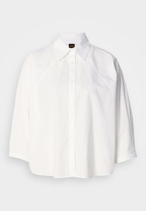 White short-sleeve shirt with a classic collar, button front, and rounded hem. Features smooth texture and subtle stitching detail.