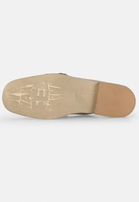 Schoenzool met een beige rubberen onderkant, voorzien van een gestructureerd grippatroon en een gegraveerd logo. Afgeronde neus en een subtiele hakdetail.