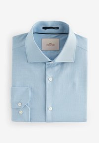 Chemise en coton à carreaux bleu clair, col classique, poignets à un bouton, avec une étiquette indiquant "NEXT SIGNATURE."