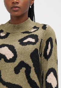 Knit green sweater featuring a leopard print pattern in black and light beige, with a crew neckline and ribbed detailing at the collar.