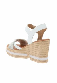 Sandalo con zeppa in pelle bianca, con cinturini incrociati, parte superiore testurizzata e suola in juta intrecciata con una striscia bianca accentata.