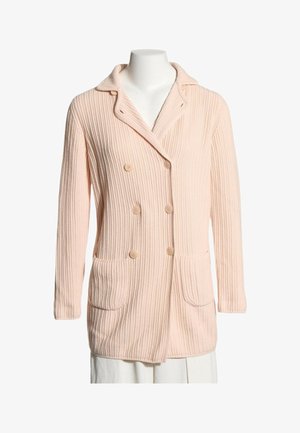 Cárdigan de punto canalé rosa claro con cierre de botones cruzados, dos bolsillos delanteros y un cuello ancho sobre un maniquí blanco.