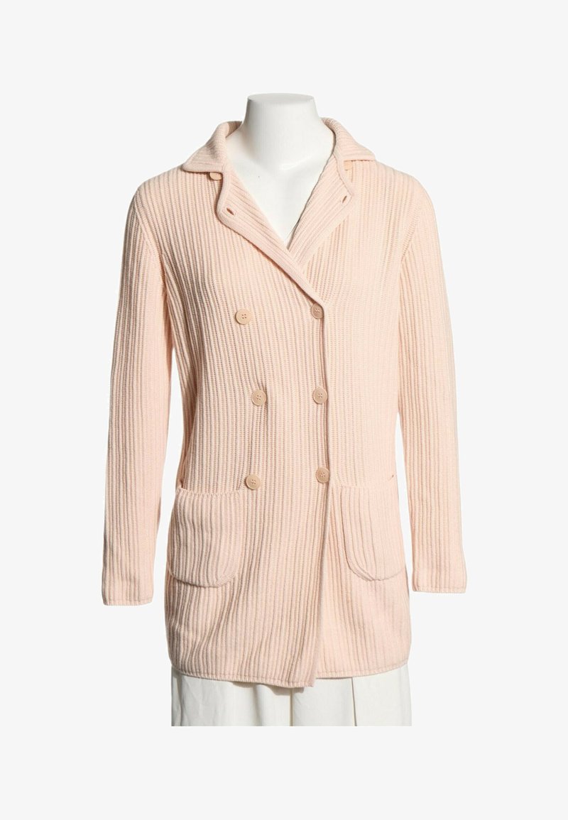 Cardigan en maille côtelée rose clair avec fermeture croisée à boutons, deux poches à l'avant et un large col sur un mannequin blanc.