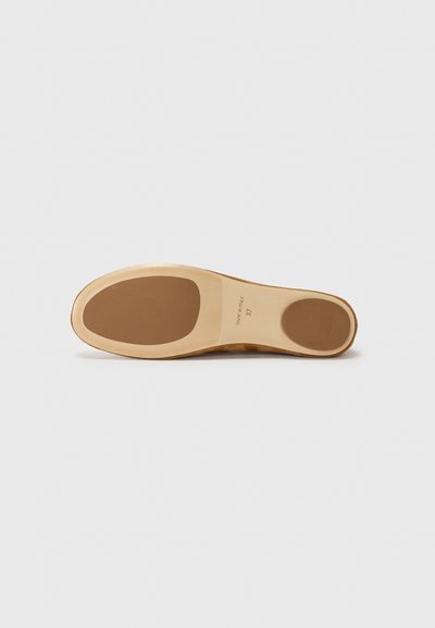 Suela de zapato de ante en marrón claro con fondo de goma. Presenta una forma redondeada, bordes limpios y un diseño minimalista. Tamaño marcado en el interior.