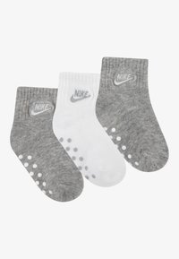 Nike zoknicsomag, két szürke pár és egy fehér pár, pamut keverékkel, bordázott mintával, logóval és pöttyös tapadóréteggel a talpakon.