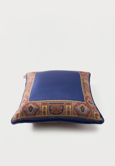 Coussin carré avec un centre uni bleu profond et une bordure ornée de motifs cachemire et floraux dans des tons chauds de rouge, or et bleu.