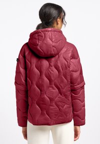 Bordeaux gevoerde jas met een capuchon, voorzien van een golvend textuurpatroon, elastische manchetten en een kortere achterkant. Gladde, glanzende stof.