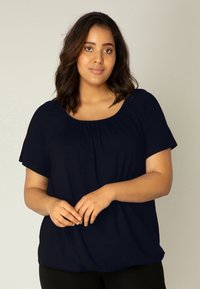 Marineblauwe blouse met korte mouwen, een ronde hals en geplooide details aan de voorkant, gemaakt van een zachte, gladde stof.