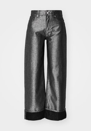 Laiene jalad hallis metallikdenimiga teksad, millel on sile tekstuur. Omab musta denimist äärist ja tavalist nööpidega sulgemist koos vöödega.