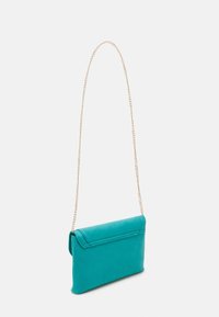 Türkise synthetische Handtasche mit umklappbarem Deckel und goldenem Kettenriemen. Glatte rechteckige Form, sanfte Textur, minimalistisches Design.