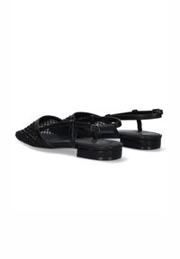 Las sandalias negras de punta afilada cuentan con una textura trenzada en la parte delantera, delgadas correas en los tobillos y un tacón bajo cuadrado. Suela plana para mayor estabilidad.