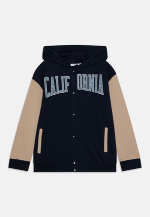 Hoodie bleu marine avec des manches beiges, arborant "CALIFORNIA" en lettres bleues claires. Matériau doux, boutons-pression à l'avant et poches latérales.