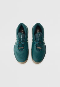 Türkise Sportschuhe mit strukturiertem Obermaterial, Mesh-Einsätzen und beigen Gummisohlen. Sie verfügen über flache Schnürsenkel und ein Logo auf der Zunge.