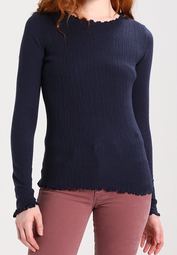 Haut à manches longues côtelé bleu marine avec un col ondulé et un ourlet festonné. Design ajusté avec des poignets volants, fabriqué en matériau tricoté doux.