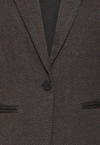 Blazer marrone a spina di pesce con rever a incavo, chiusura con un solo bottone e due tasche laterali, realizzato in tessuto strutturato.