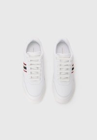 Sneakers bianchi con una texture liscia, caratterizzati da un design con lacci, un logo discreto sulla linguetta e colori a strisce rosso e blu navy sui lati.