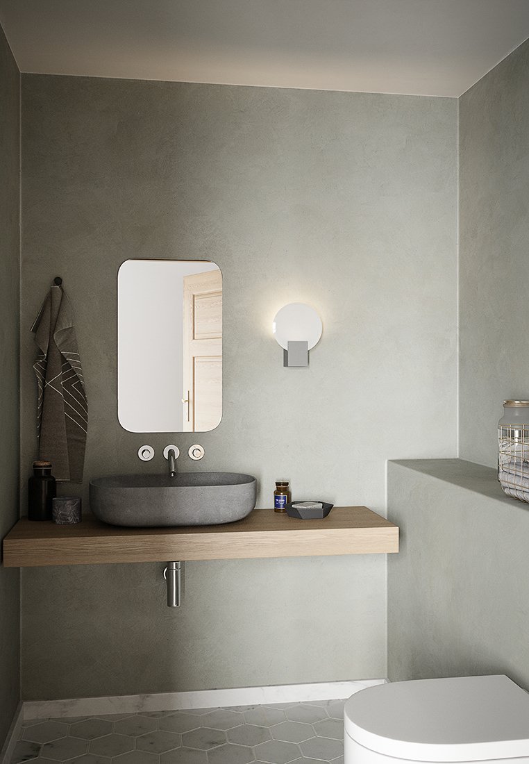 Modernes minimalistisches Badezimmer mit wandmontiertem rechteckigem Spiegel, grauem Steinsch sink auf einem Holzhregal, runder Wandlampe und Handtüchern, die an einem Haken hängen.