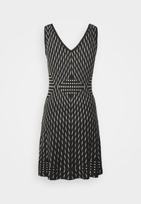 Czarna i kremowa sukienka z dekoltem w serek, z geometrycznym wzorem ukośnych linii oraz paskami na talii i u dołu.