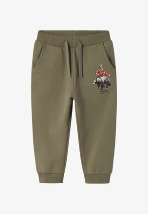 Olivengrønne sweatpants med elastisk talje og lommer, der har et grafisk motiv af en vaskebjørn og en ræv oven på en bjørn, med ordet "VENNER."