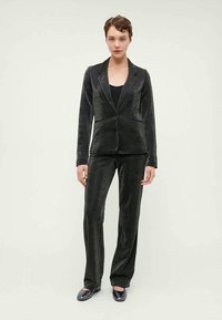 Set din blazer și pantaloni texturat negri cu o strălucire subtilă. Blazerul are rever și un nasture, croială ajustată, iar pantalonii au croială dreaptă.