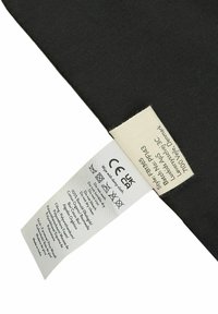 Juodas audinys su priežiūros etikete, kurioje pateiktos skalbimo instrukcijos. Etiketė apima CE sertifikatą ir informaciją apie medžiagos sudėtį.