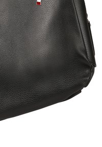 Zwart leren tas met een gestructureerd ontwerp, voorzien van een klein rood-wit logo-accent aan de voorkant en een ritssluiting.