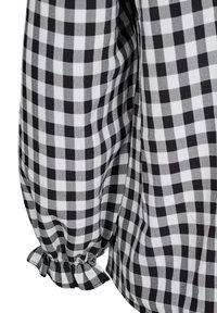 Checkered blouse featuring black and white gingham pattern, lightweight fabric, puffed sleeves, and gathered cuffs with ruffle detail.