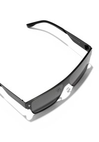 Ochelari de soare negri cu un design elegant, dotati cu o lentilă închisă, formă rectangulară și accente texturate pe brațe. Construcție ușoară.