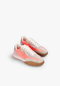 Zapatillas deportivas con una mezcla de materiales sintéticos en coral y rosa, acentos de ante, cordones blancos y una suela de goma texturizada.