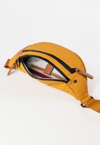 Borsa a vita gialla in tessuto con un accento in pelle marrone. Presenta un'apertura con cerniera che rivela un interno a motivi a griglia e una cintura regolabile.