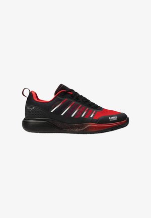 Zapatilla deportiva negra y roja con una parte superior de malla texturizada, prominentes rayas blancas y una suela roja salpicada. Presenta un diseño acolchado y una lengüeta para tirar.
