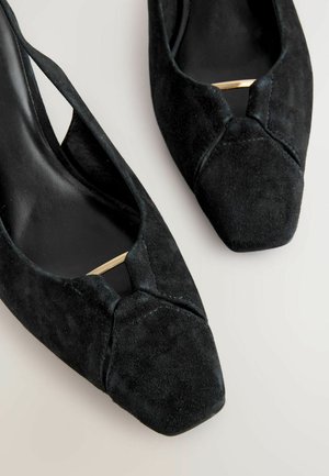 Czarne zamszowe szpilki z noskiem w kształcie ostrym i wycięciami. Posiadają złoty akcent na cholewce oraz gładką, matową teksturę.