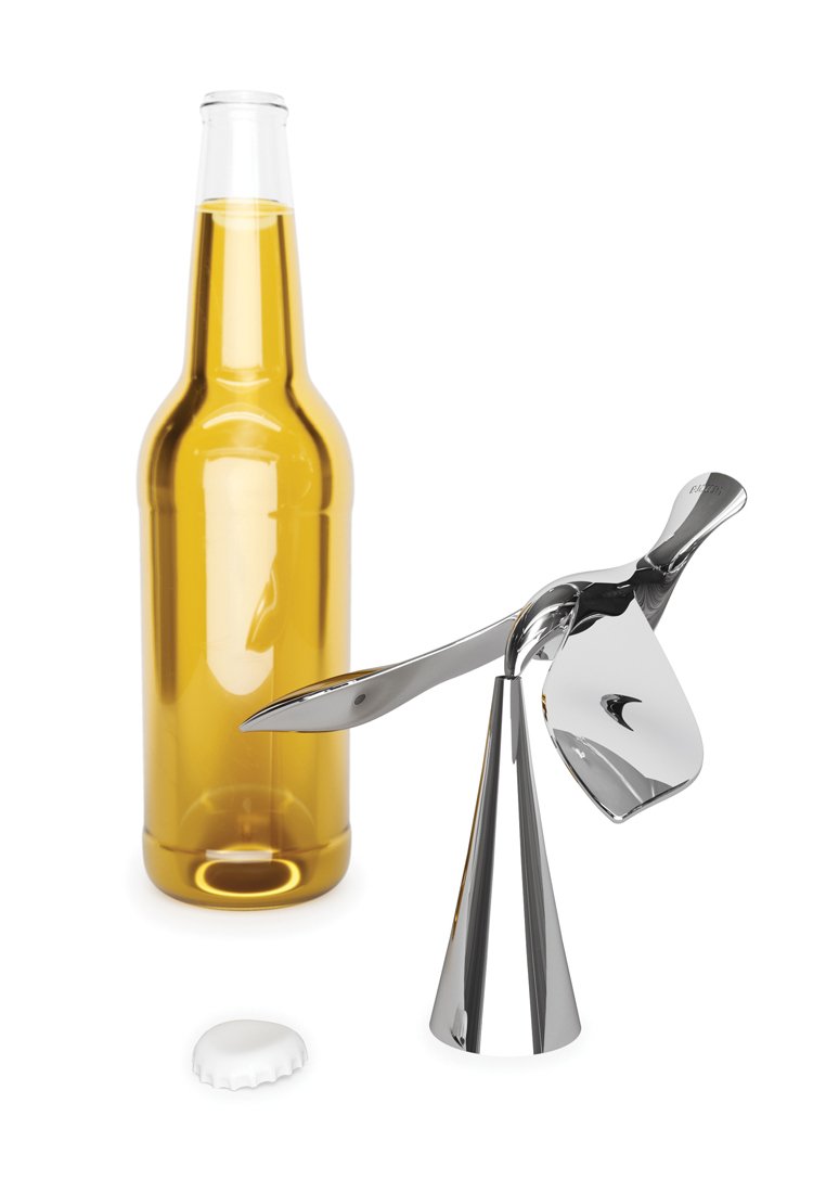 Ein Flaschenöffner aus Edelstahl mit einem eleganten, geschwungenen Griff, der neben einer braunen Glasbierflasche und einem weißen Flaschenverschluss liegt.