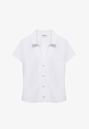 Bluza albă cu mâneci scurte, cu guler și patru nasturi tip noduri din material pe față, având un croi ușor scurtat.