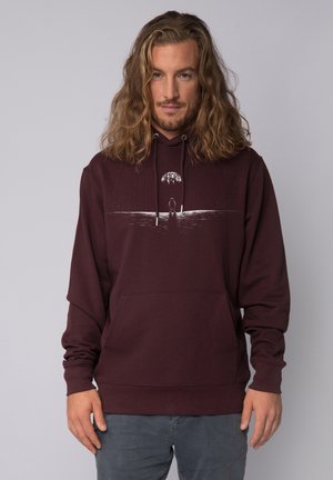 Bordeaux hoodie met een kangoeroezak, voorzien van een afbeelding van een silhouet en een maan boven een waterlijn. Zachte stof en hoodie met een trekkoord.