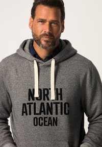 Felpa grigia con cappuccio doppio e cordini crema. Presenta una stampa nera audace che riporta la scritta "OCEANO ATLANTICO NORD" sul davanti.
