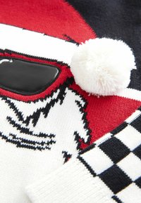 Rood en zwart sweater met een Santa-gezicht, voorzien van een witte pompon en een geruit patroon op de manchetten. Zachte gebreide textuur.